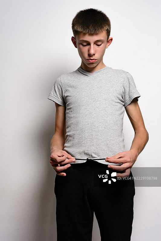 一个少年正在系他的裤子图片素材