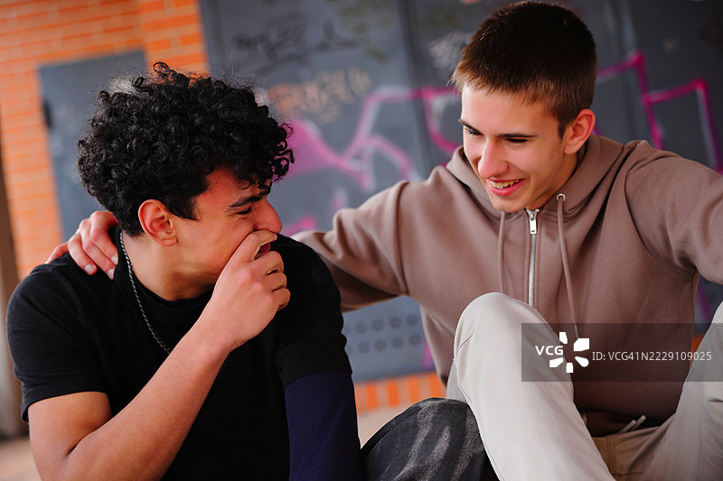 两个青少年男孩在户外欢笑，友谊概念，西班牙图片素材