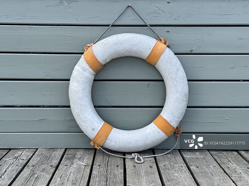 一个橙白相间的救生圈挂在码头上图片素材