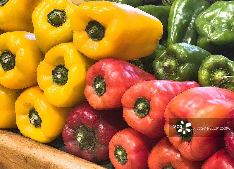 一组黄色、红色和绿色的辣椒在超市柜台上图片素材