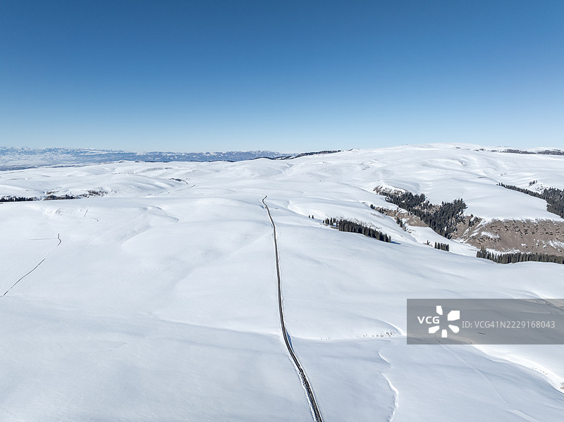 高角度视图的雪原道路与雪山相映成趣图片素材