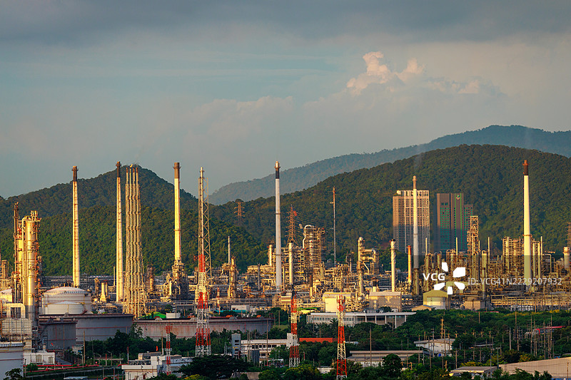 石油和天然气石化工业的景观，炼油厂的油储罐和钢管道，工业区的炼油厂，日落时的生态系统和健康环境图片素材