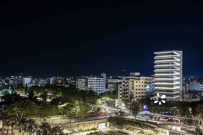 塞浦路斯岛尼科西亚的天际线，现代摩天大楼和办公大楼在夜间灯光照耀下。图片素材