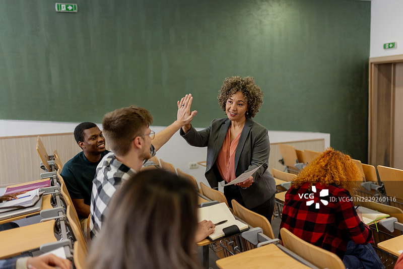 女大学老师与学生在教室里击掌庆祝图片素材