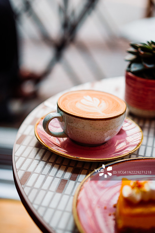 温暖的拿铁艺术咖啡在桌上，营造出舒适的氛围图片素材