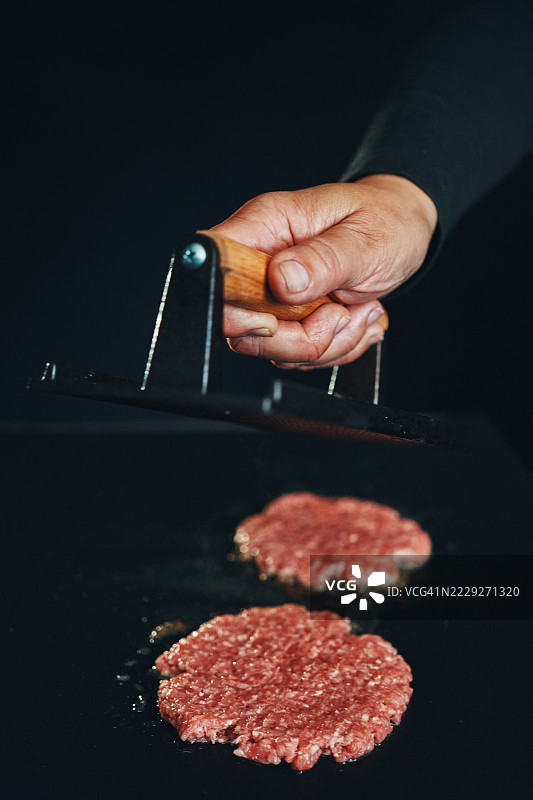在烧烤架上准备压扁的汉堡肉饼图片素材
