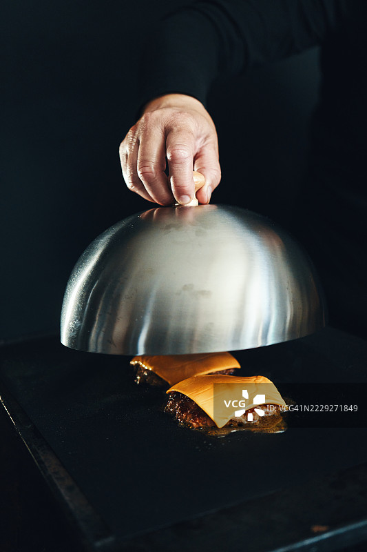 在烧烤架上准备压扁的汉堡肉饼图片素材