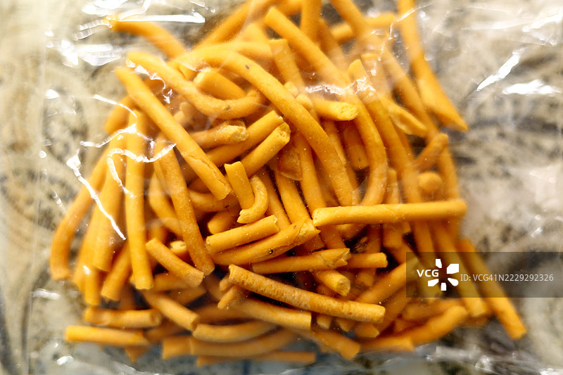 装在透明塑料袋中的炸脆咸味小吃或用鹰嘴豆粉制成的面条。图片素材