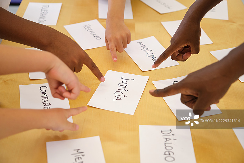 孩子们指着写有关于价值观的西班牙单词的卡片图片素材