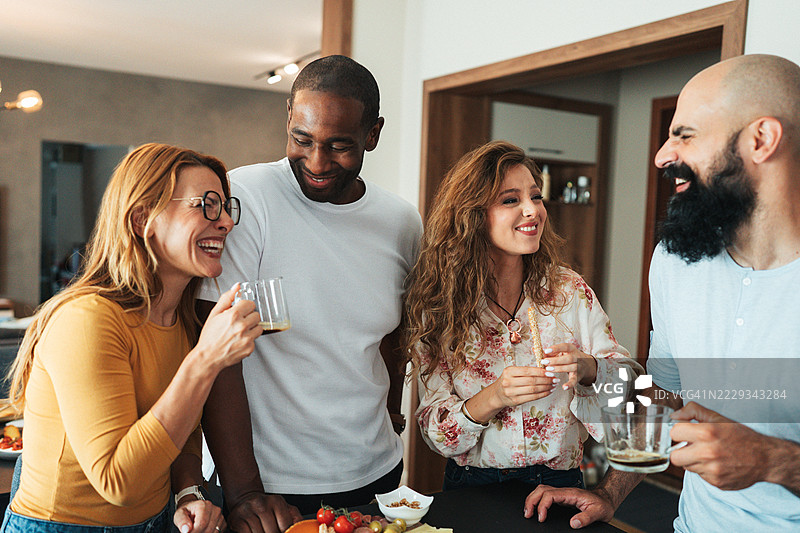 一群朋友在轻松的家庭聚会上享受比萨和葡萄酒图片素材