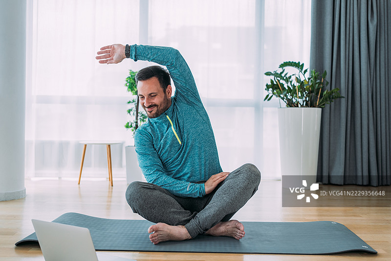 年轻人在家锻炼。图片素材