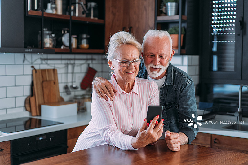一对情侣在家中通过智能手机进行视频通话。图片素材