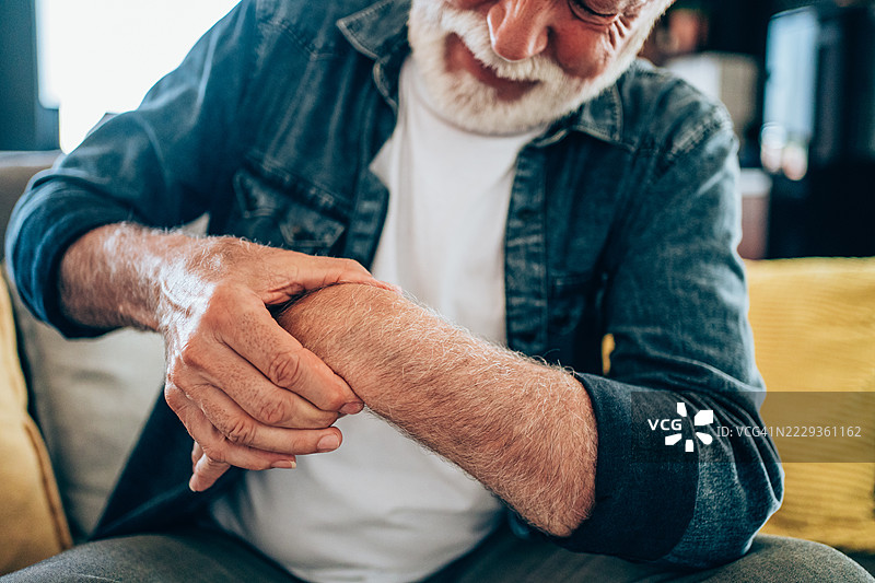 老年男子按摩手腕疼痛的手图片素材