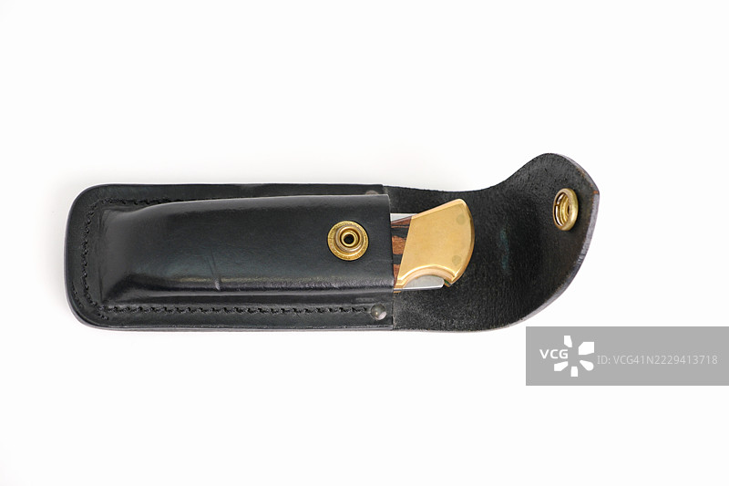 高角度视图的折叠刀，配有黑色皮革套。图片素材