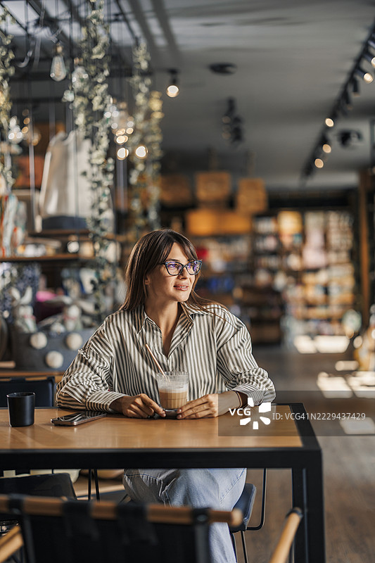 女人坐在咖啡馆里，享受一杯咖啡图片素材
