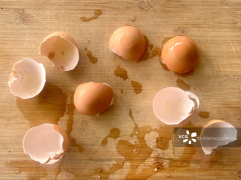 打开的蛋壳放在木质切菜板上图片素材