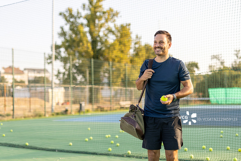 男子在阳光明媚的户外网球场上享受练习时光图片素材