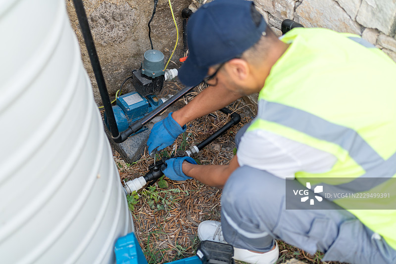 水管工正在修理水储罐的水泵电机图片素材