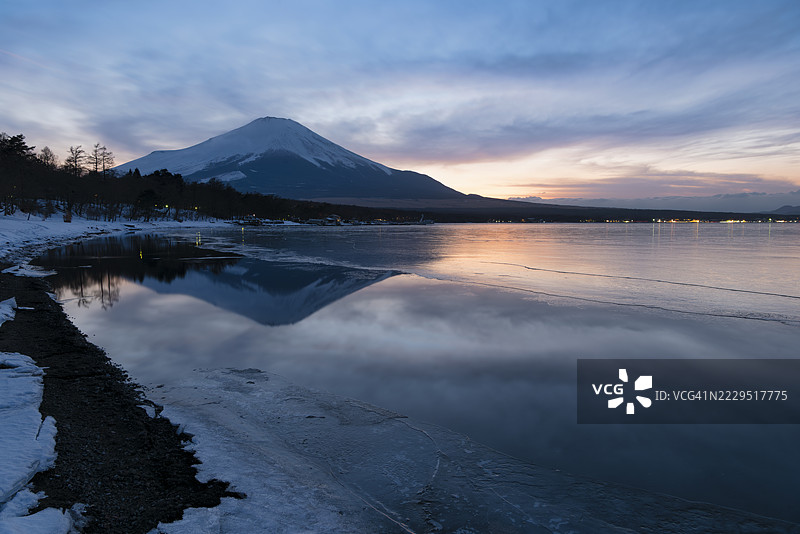 冬季日落时富士山倒映在冰冻湖面上图片素材