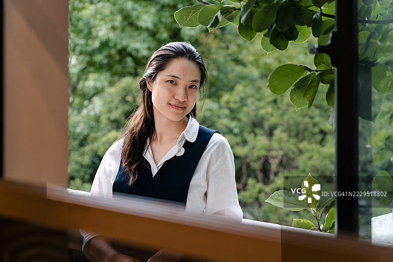 透过窗户看到的亚洲美女肖像图片素材