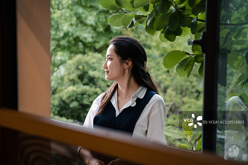 透过窗户看到的漂亮亚洲女性肖像图片素材