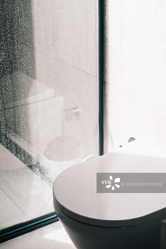 现代、时尚的马桶和湿润的玻璃淋浴墙的室内拍摄。图片素材