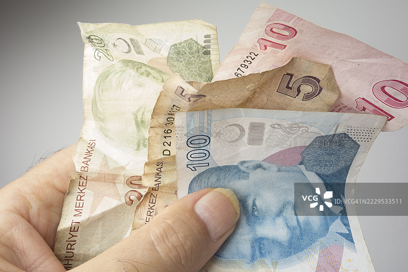 手持土耳其里拉纸币的人图片素材