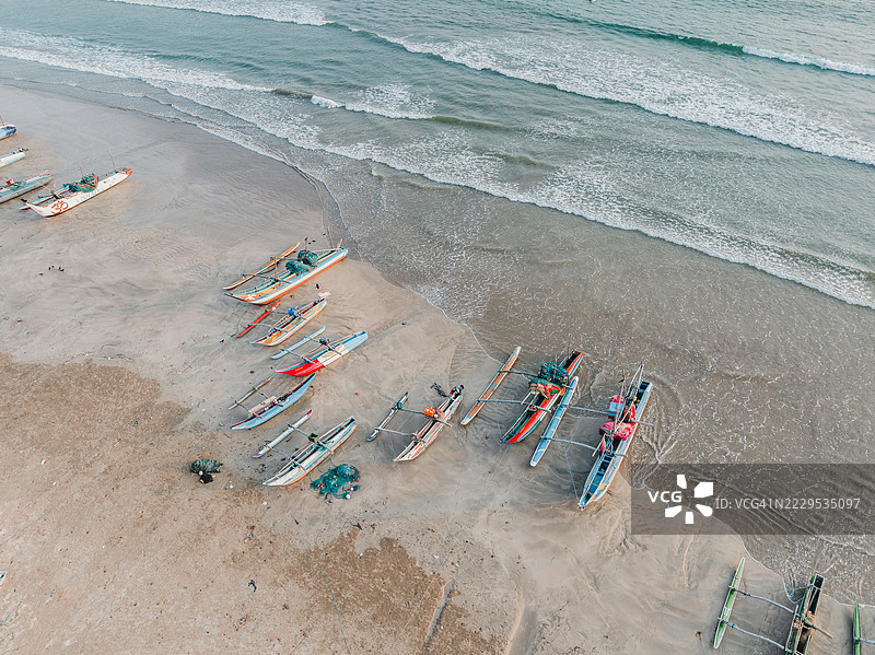 空中拍摄的图像显示斯里兰卡传统的独木舟停靠在印度洋旁的海滩上，地点为丹尼皮提亚，马塔拉区，南方省，斯里兰卡图片素材
