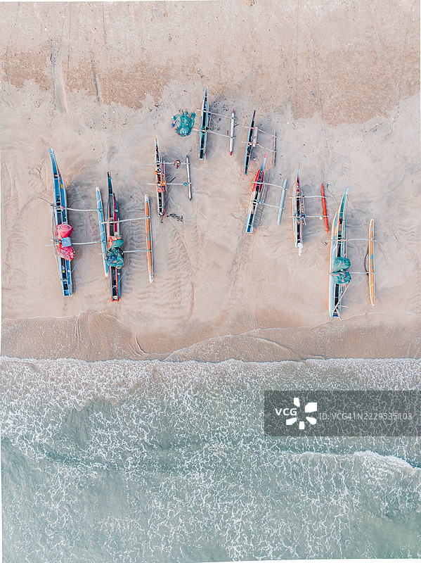 一排传统斯里兰卡独木舟停靠在印度洋旁的海滩上，照片是从无人机视角拍摄的，地点为斯里兰卡南部省马塔拉区的德尼皮提亚。图片素材