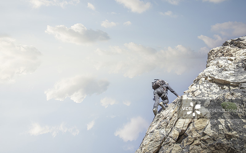 登山者攀爬岩壁。图片素材