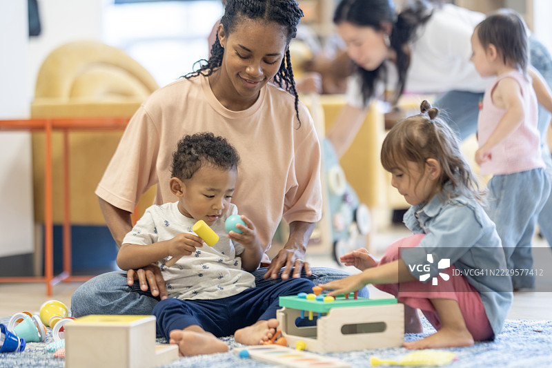 幼儿园中不同年龄段的儿童和成人一起玩耍图片素材