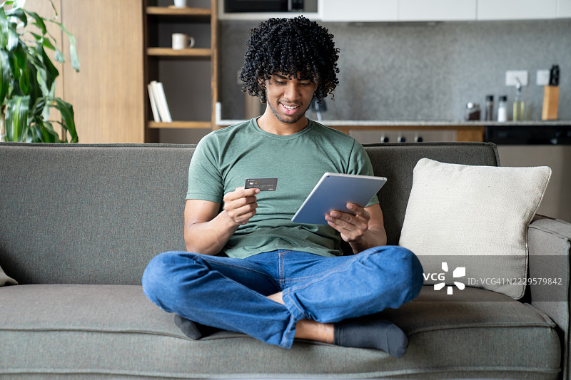 在家中在线购物并使用信用卡付款的男子图片素材