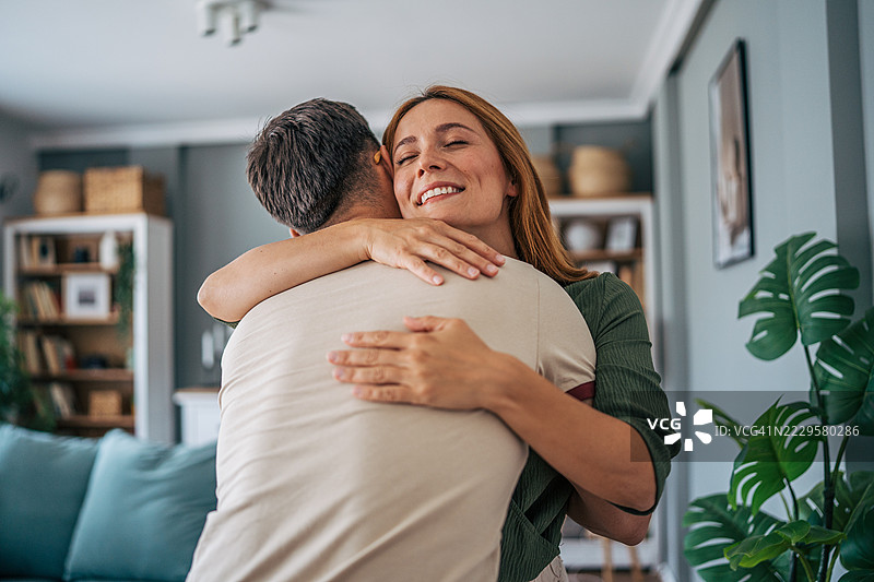 幸福的情侣在客厅温柔相拥图片素材
