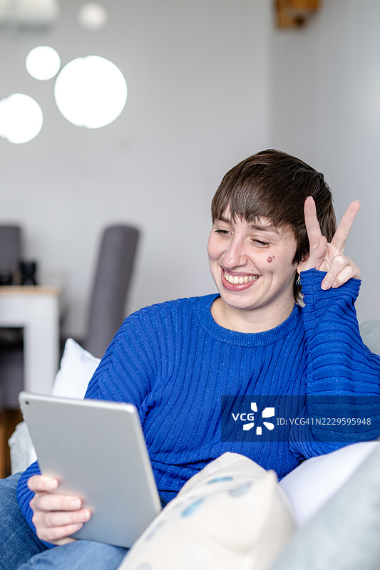 年轻女子在公寓中使用电子设备图片素材