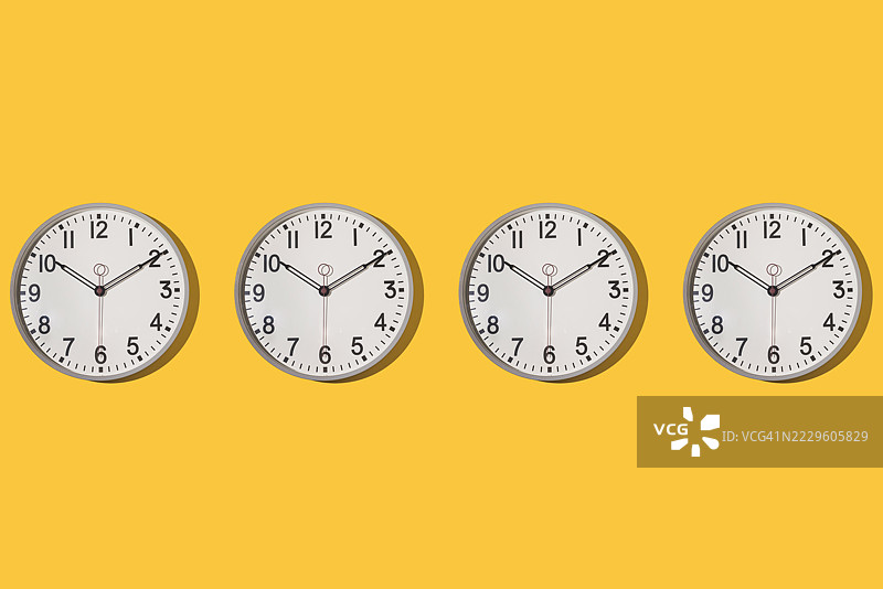一排墙钟的图案，显示时间为10点10分，背景为黄色。时间、小时、分钟、秒钟、测量工具。图片素材