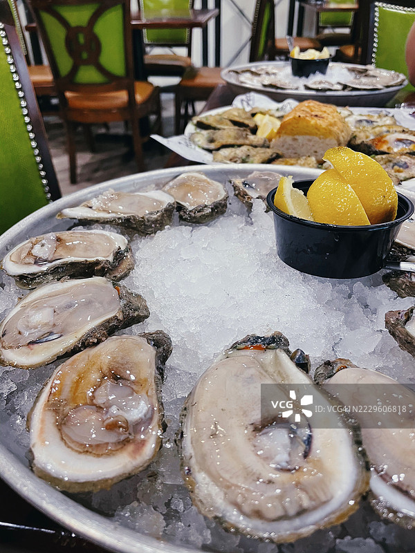 新鲜生蚝特写，配有碎冰和柠檬角，摆放在海鲜餐厅中。图片素材