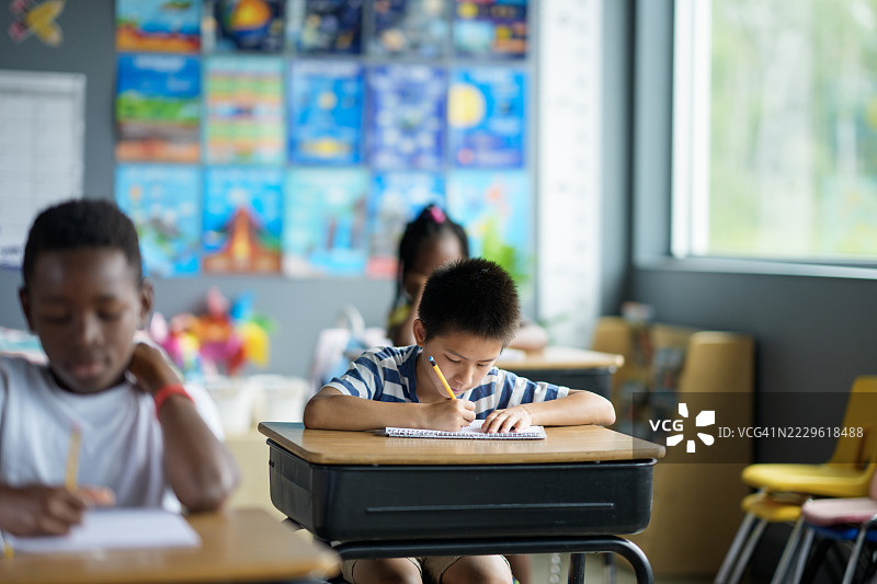 学生们在明亮的教室环境中专注于写作图片素材