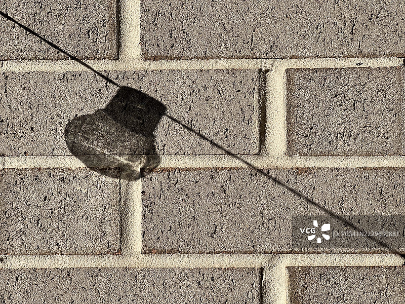 灯泡的影子投射在砖墙上图片素材