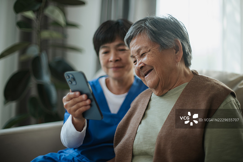 护理人员协助老年女性进行视频通话。图片素材