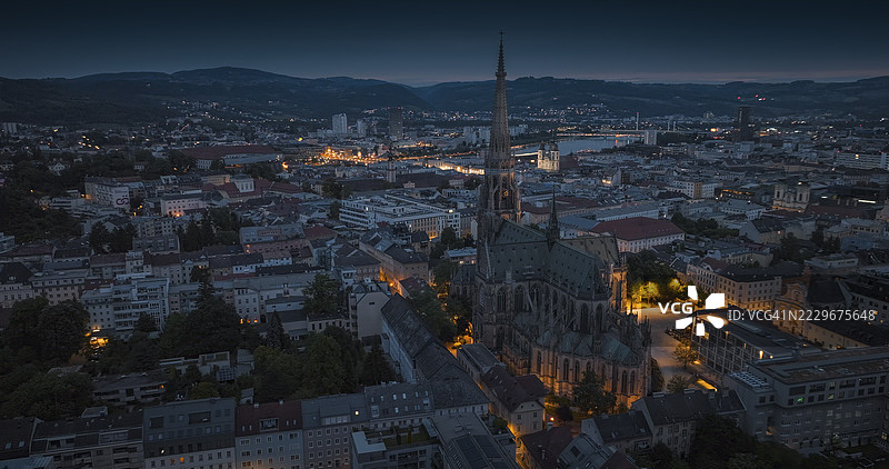 黄昏时分的林茨鸟瞰图，灯光照亮的教堂图片素材