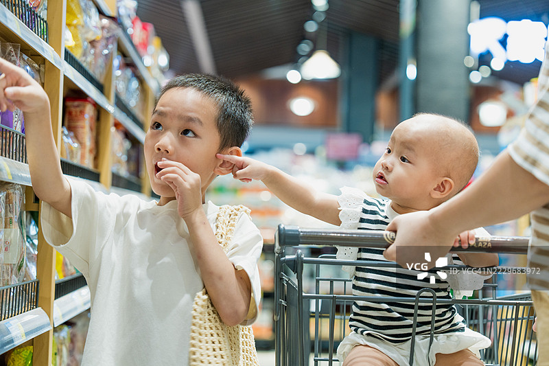 亚洲女孩和哥哥在商场购物；婴儿女孩部分面部特征的特写图片素材