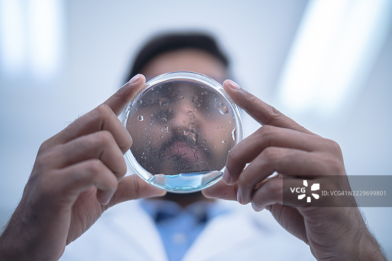 科学家在实验室环境中检查培养皿，进行研究和实验分析，推动科学发现和创新。图片素材