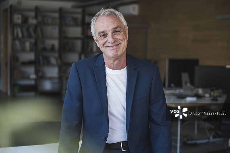 快乐的商人在办公室里站着图片素材