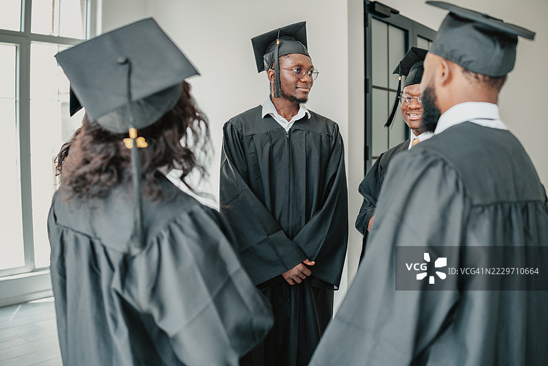 在校园里，来自不同背景的大学生们欢庆毕业成功，享受快乐的友谊时光。图片素材