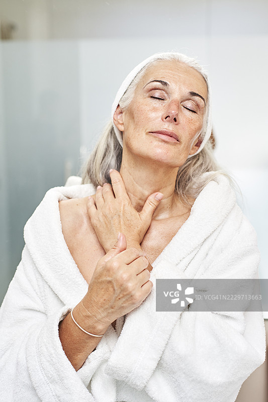 女人在浴室里闭着眼睛按摩脖子图片素材