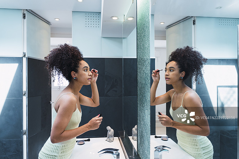 女人在家镜子前涂睫毛膏图片素材