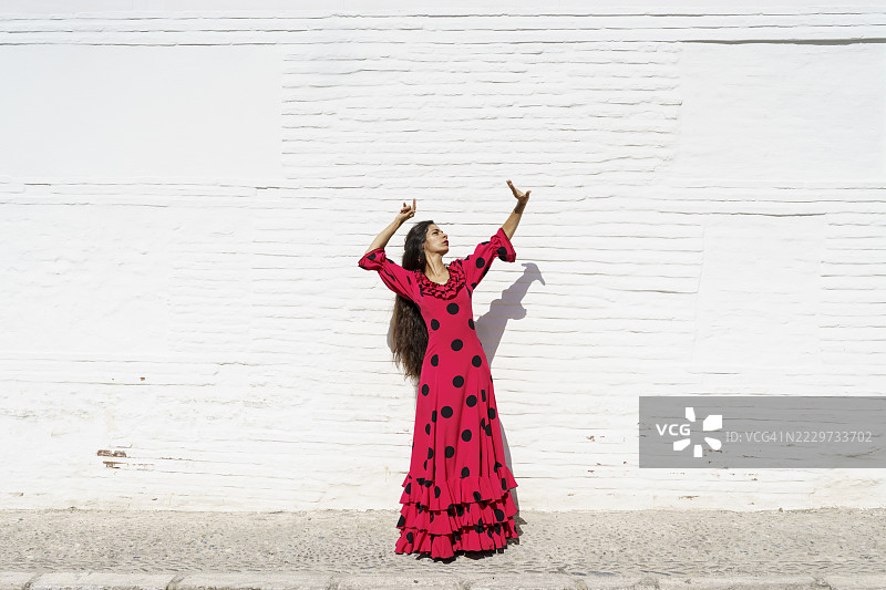 在白色墙壁前举手的弗拉门戈舞者图片素材