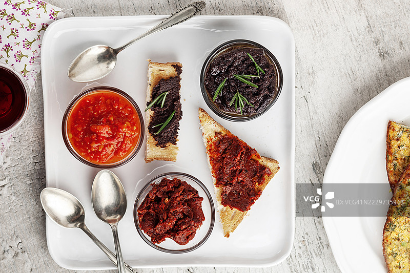 早餐选择。面包配橄榄酱、橄榄泥、黑橄榄塔帕纳德、酱汁、辣椒酱。早餐酱汁。土耳其乡村早餐桌。图片素材
