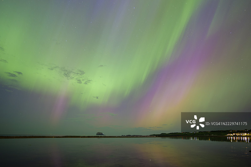 英国，苏格兰，北贝里克，夜晚海滨小镇上空的北极光图片素材