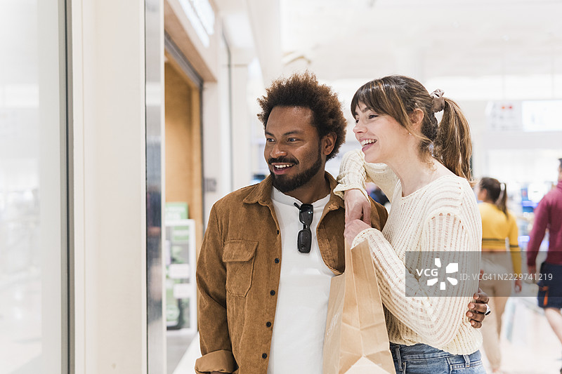 快乐的多种族情侣在商场里逛街购物图片素材
